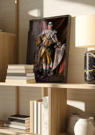 Cool King by Dikhotomy in a dark frame on a wooden shelf beside books and a lamp