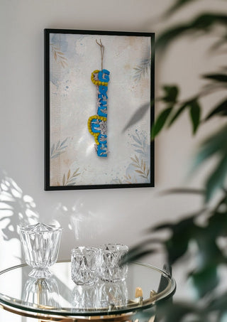 GREECE Terracotta by Ammar in a black frame above a glass table with crystal glassware