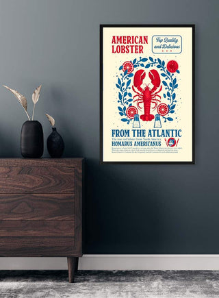 Framed "American Lobster" vintage poster on a dark wall, beside a wooden sideboard with vases.