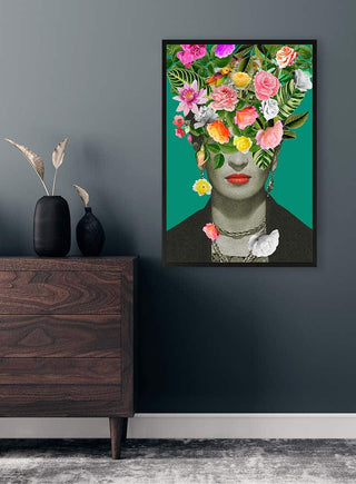 Colorful floral Mexican artist portrait on green background, displayed on a modern wall above a wooden dresser.