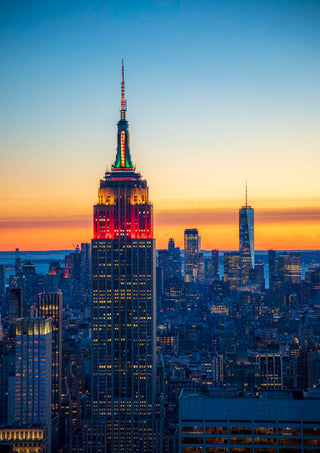 Empire State Building lit up at sunset with Manhattan skyline, featured in Blue Manhattan by Danny Gao.