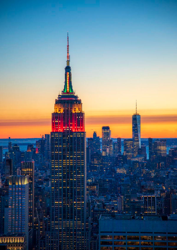 Empire State Building lit up at sunset with Manhattan skyline, featured in Blue Manhattan by Danny Gao.