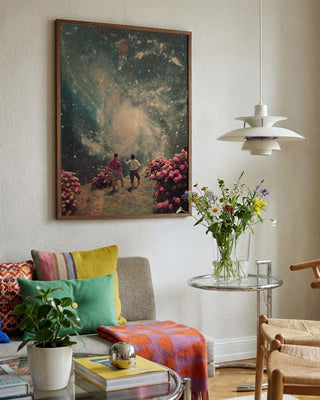 There Will Be Light In the End by Frank Moth displayed on a living room wall above a cozy sofa and flowers.
