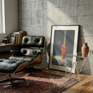 Spacecolor - Frank Moth art print rests against a concrete wall in a cozy, modern reading nook with lounge chair.