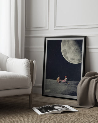 Framed print of "I Gave You the Moon for a Smile" by Frank Moth leaning against a wall in a modern room.