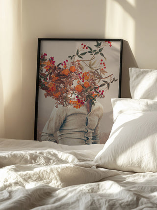 Framed Roots Bright art by Frank Moth featuring a person with a head of colorful flowers, displayed beside a bed.
