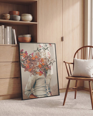 Framed Roots Bright art print by Frank Moth leaning against a wooden shelf in a cozy, modern room.