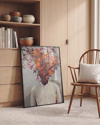Framed Bright Bloom - Frank Moth print with floral head, leaning on a wooden cabinet in a cozy room.