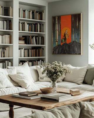 "The Departure" by Frank Moth displayed above a cozy sofa in a modern, book-filled living room.