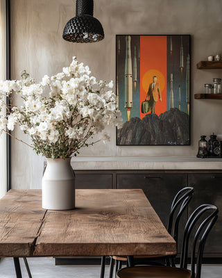 "The Departure" by Frank Moth art print on wall in a cozy dining room with rustic table and white flowers.