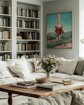 Framed "Enemy" by Frank Moth on wall above a cozy sofa, surrounded by bookshelves in a modern living room.