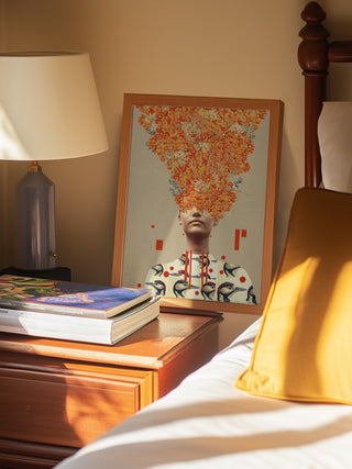 Art print of a woman’s head with autumn leaves and birds, titled "Bird Flight In Autumn" by Frank Moth, on a bedside table.