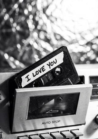 Cassette tape labeled "I Love You" partially inserted in a vintage cassette player.