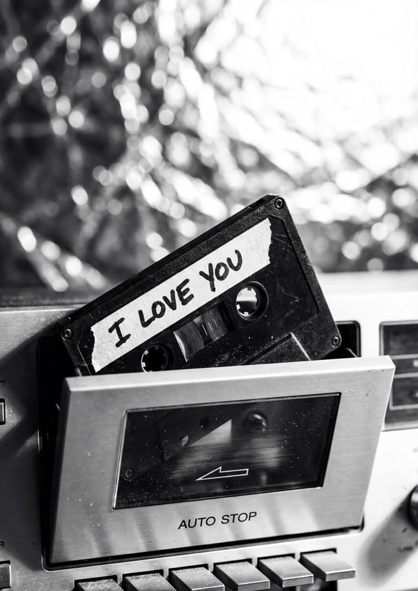 Cassette tape labeled "I Love You" partially inserted in a vintage cassette player.