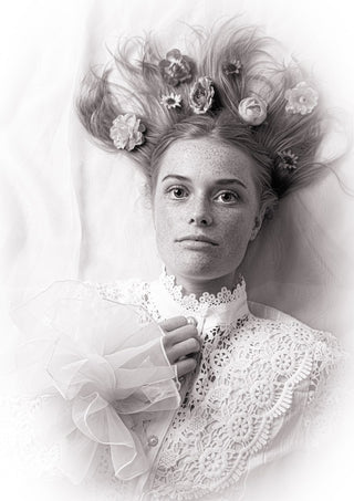 Klara by Bettinafloorphoto - a girl in white lace with pale flowers in her hair, in black and white