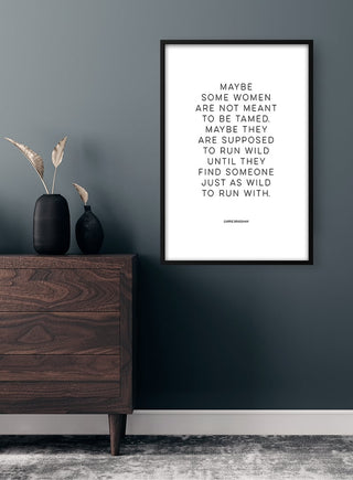 Minimalist Carrie Bradshaw quote poster on dark wall above wooden dresser with vases, titled "Run Wild"