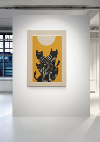 Framed artwork of abstract black cats with white stripes on a yellow background, by Branka Kodžoman.