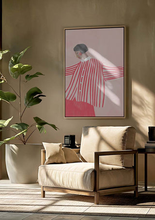 Framed print of "The Woman With the Red Stripes" by Bea Muller hanging above a beige armchair in a modern living room.
