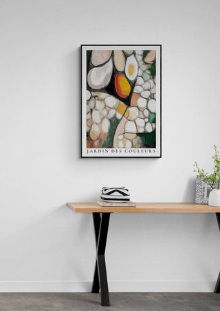 Framed abstract Jardin Des Couleurs artwork with colorful shapes, displayed above a wooden table in a modern room.