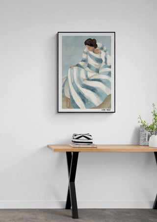 Framed print of Cherish by Elara Monet hanging above a wooden desk with small decor accents.