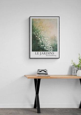Poster of Le Jardin Du Luxembourg 04 with floral art, framed and hung above a wooden table in a minimalist room.