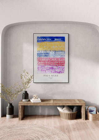 Framed "Old City" by Paul Klee on a light gray wall above a wooden bench with decor in a modern room.