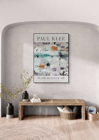 Framed "In the Realm of Air 1917" by Paul Klee displayed above a wooden bench in a modern room.