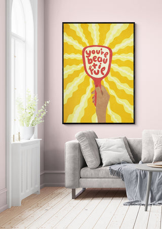 Framed "Beautiful" by Raissa Oltmanns displayed above a sofa in a bright living room.