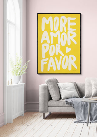 Framed "More Amor Por Favor" yellow wall art above a light gray sofa in a bright, modern living room.