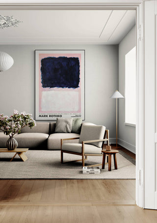 Framed Rothko Retroperspective 1903 poster displayed above a modern beige sofa in a stylish living room.