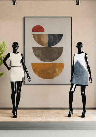 Two mannequins in stylish dresses stand by a geometric art print titled Autumn Dream 03 on a beige wall.