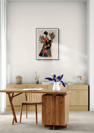 Framed Floral Serenity - Elara Monet artwork displayed above a modern wooden desk and chair in a minimalist room.