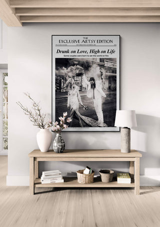 Framed Drunk On Love Artsy Edition print displayed above a modern wooden console table with decor.