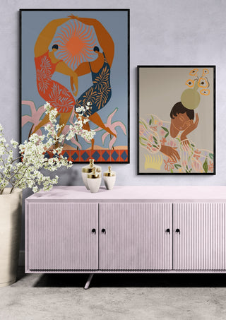 Two framed Arty Guava art prints, including Pass Me The Pear, displayed above a pastel credenza.