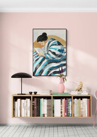 Framed "Eyes Are Made For Reading" artwork by Martin Zen above a shelf with books and decorative items.