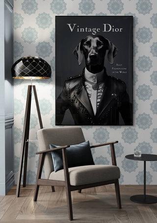 Framed Vintage Dior poster featuring a dog in formal attire, displayed above an armchair and lamp.
