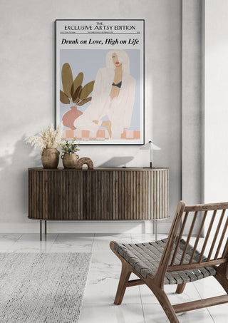 Minimalist room with the Love Life - Artsy Edition poster above a wooden console and wicker chair.