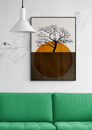 Winter Days by Boris Draschoff artwork featuring a bare tree over an orange sun, displayed above a green sofa.