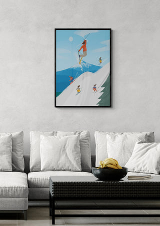 Framed Ski Girls artwork featuring female skiers on a snowy mountain, displayed above a modern sofa.