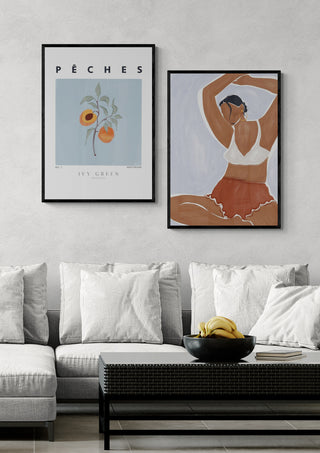 Framed art of a woman doing yoga in an ivy green bikini displayed above a modern sofa.