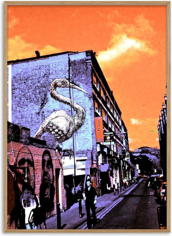 Brick Lane Pelican by Pelecan Schneider - pelican mural on a London brick gable under a burning orange sky