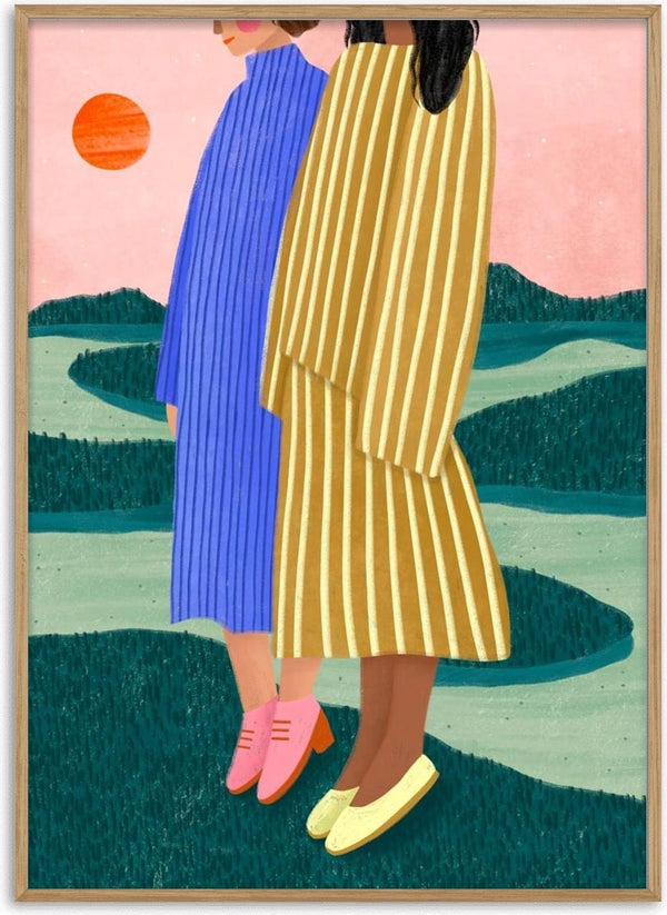 Two women in striped dresses stand together outdoors at sunset, one in blue, one in yellow.