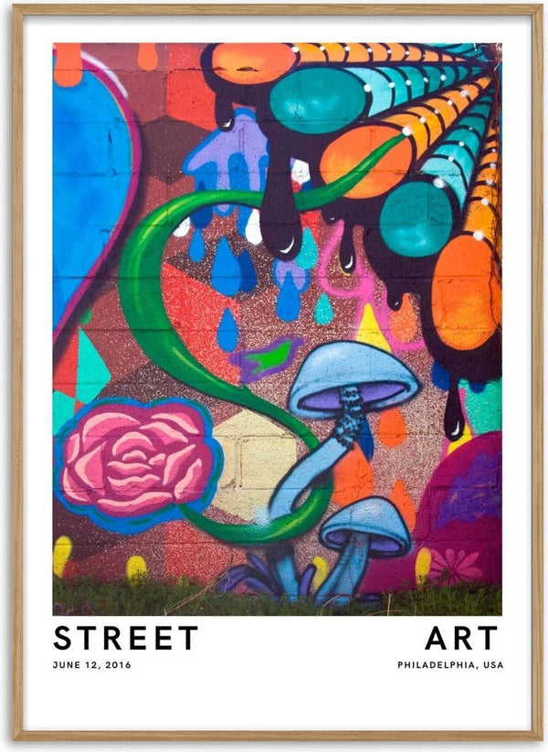 Colorful Philadelphia street mural featuring mushrooms, a pink rose, and abstract vibrant shapes on a brick wall.
