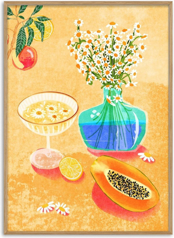A vase of daisies, a cocktail, papaya, and citrus decorate a table in Summer Day Vibes by Raissa Oltmanns.