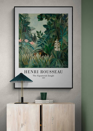 Framed print of "The Equatorial Jungle" by Henri Rousseau displayed above a modern light wood cabinet.