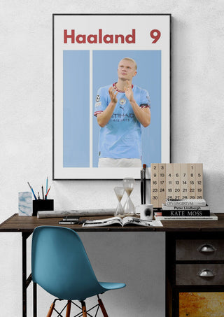 Poster of Haaland in a Man City kit with "Haaland 9" text, displayed above a modern desk setup.